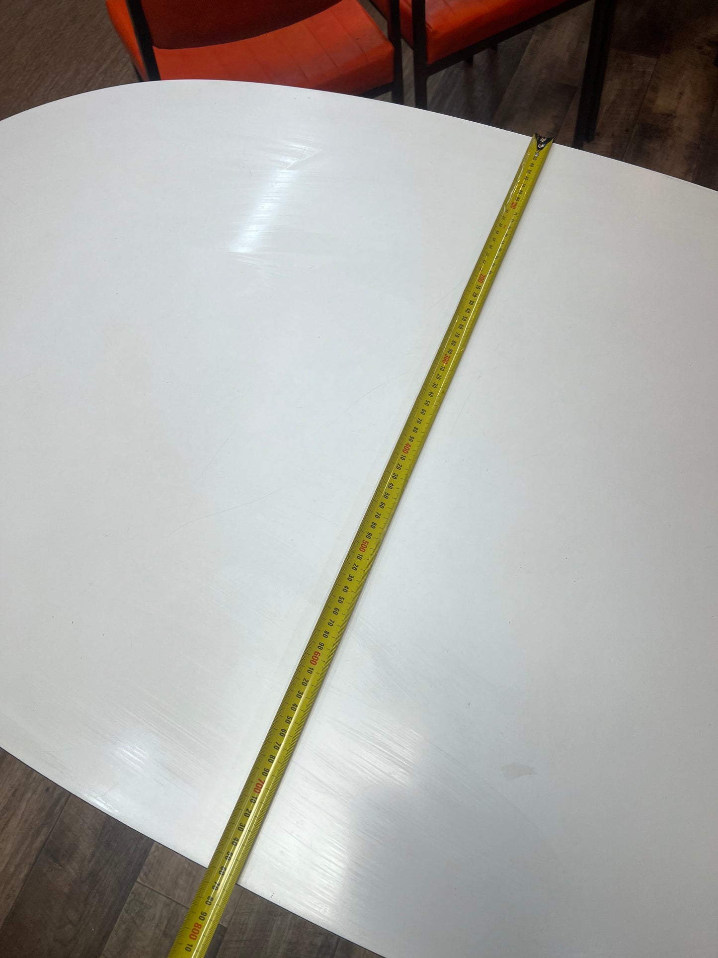 White oval dining table with black steel pedestal base