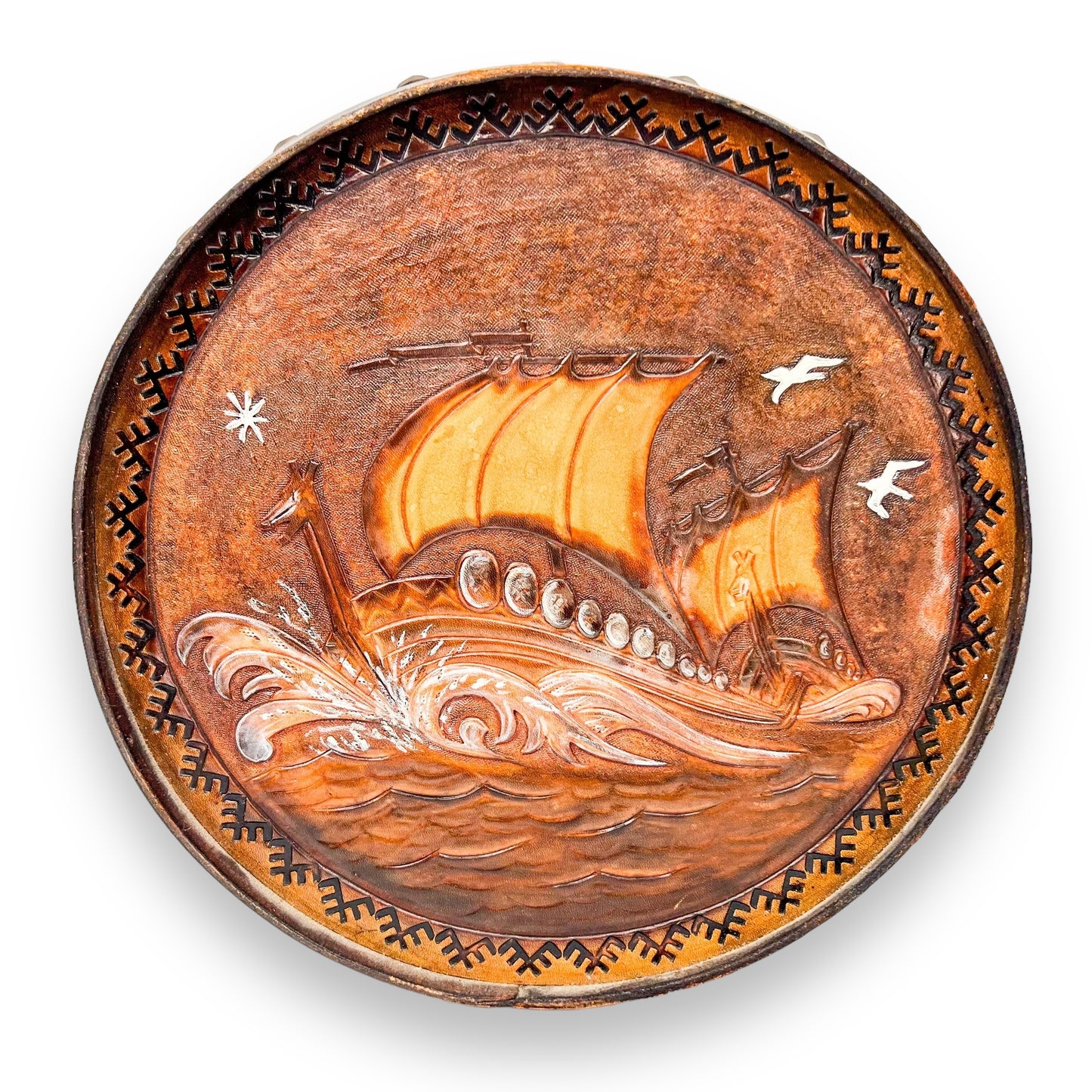 Vintage brown leather round hanging artwork with ship artwork.