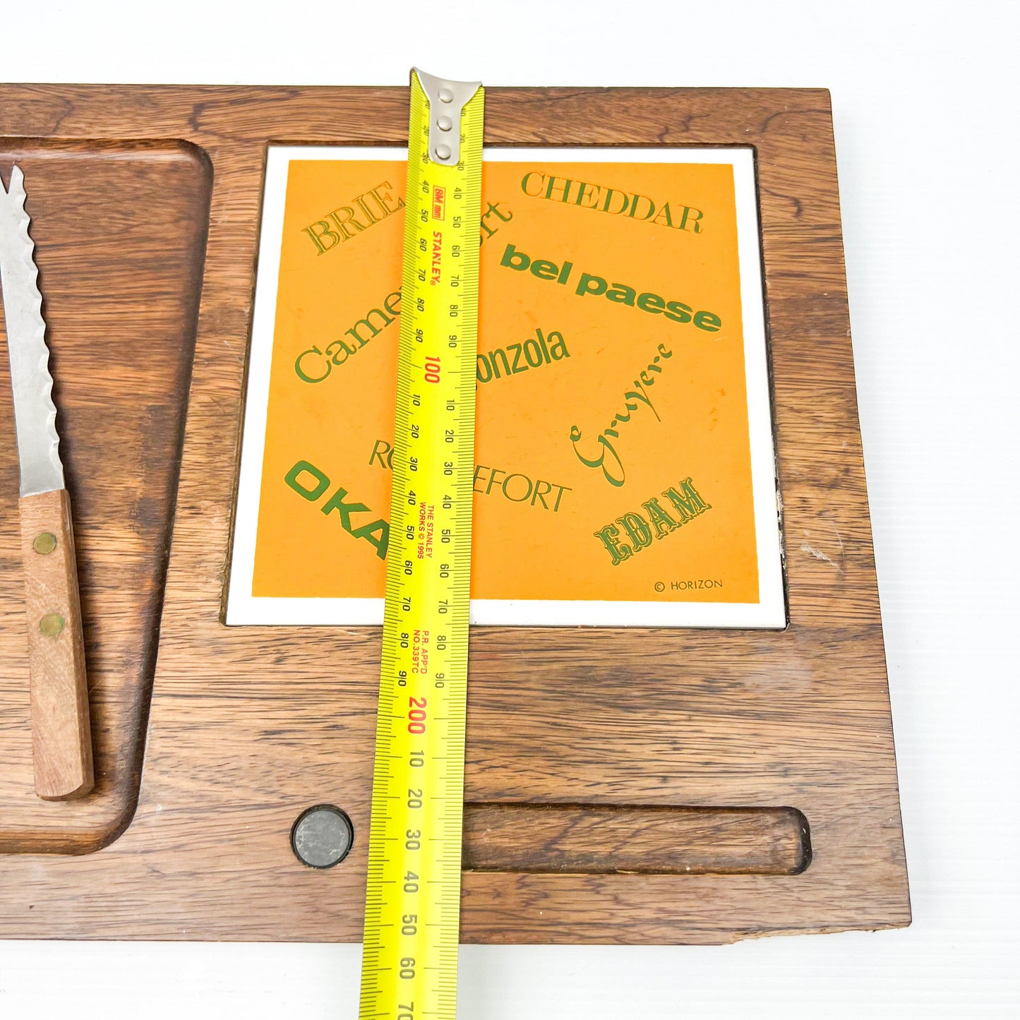 Wooden cheese board with cheese name tile and knife