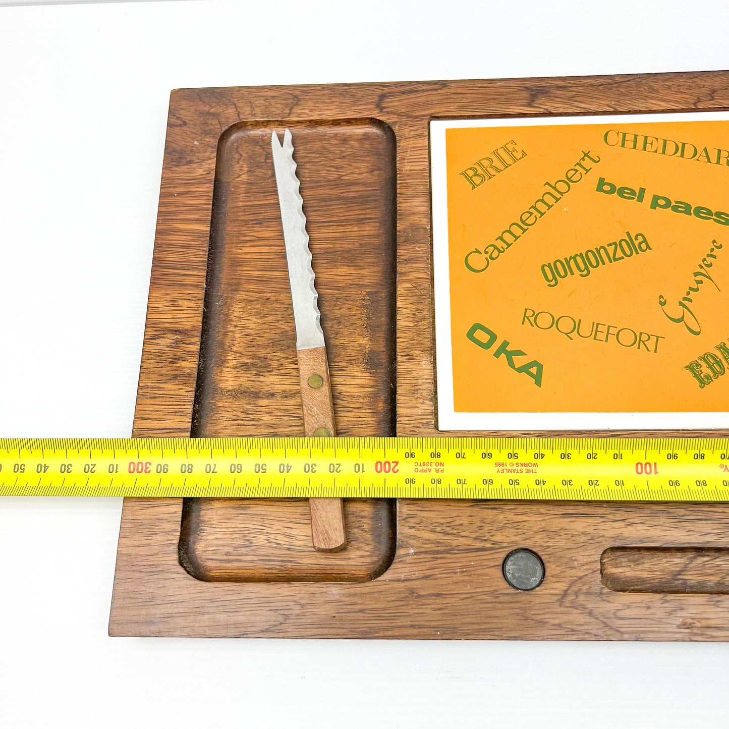 Wooden cheese board with cheese name tile and knife