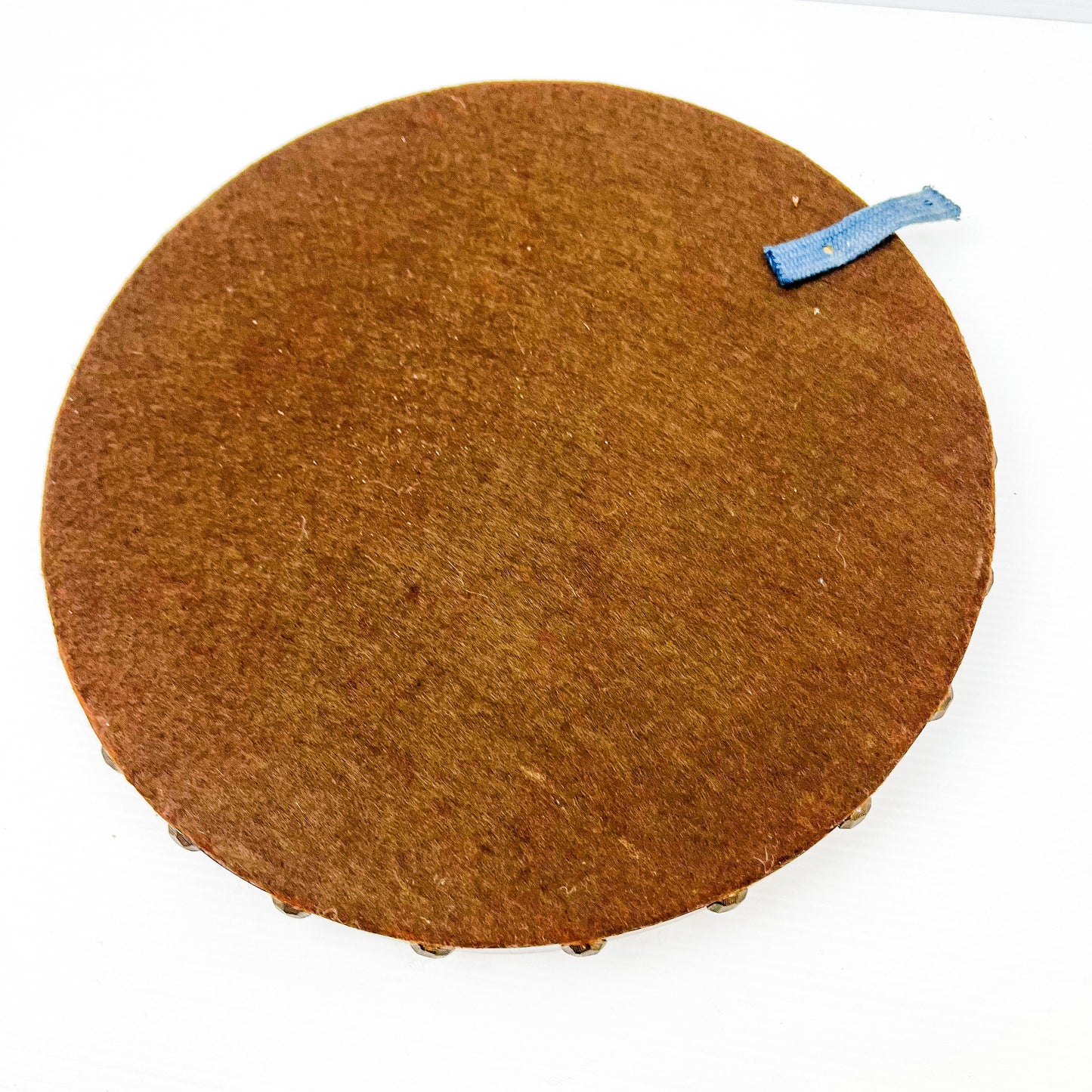 Vintage brown leather round hanging artwork with ship artwork.