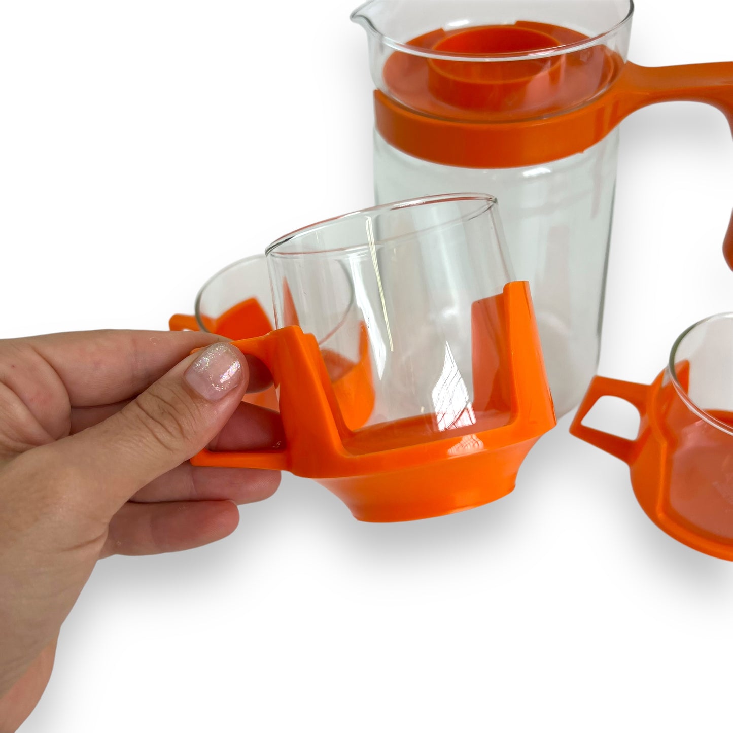 JAJ Pyrex Clear glass jug & 3 cups with orange plastic handles and lid.