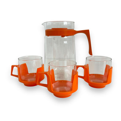 JAJ Pyrex Clear glass jug & 3 cups with orange plastic handles and lid.