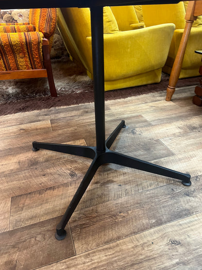 White oval dining table with black steel pedestal base