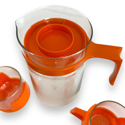 JAJ Pyrex Clear glass jug & 3 cups with orange plastic handles and lid.