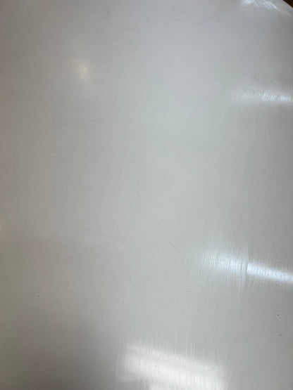 White oval dining table with black steel pedestal base