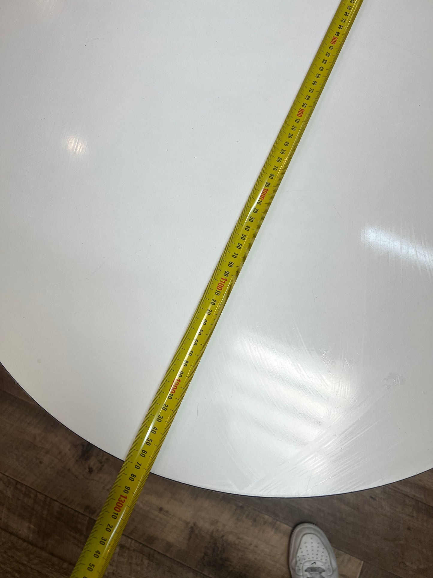 White oval dining table with black steel pedestal base