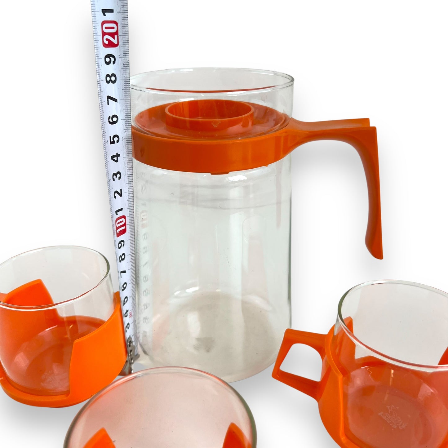 JAJ Pyrex Clear glass jug & 3 cups with orange plastic handles and lid.