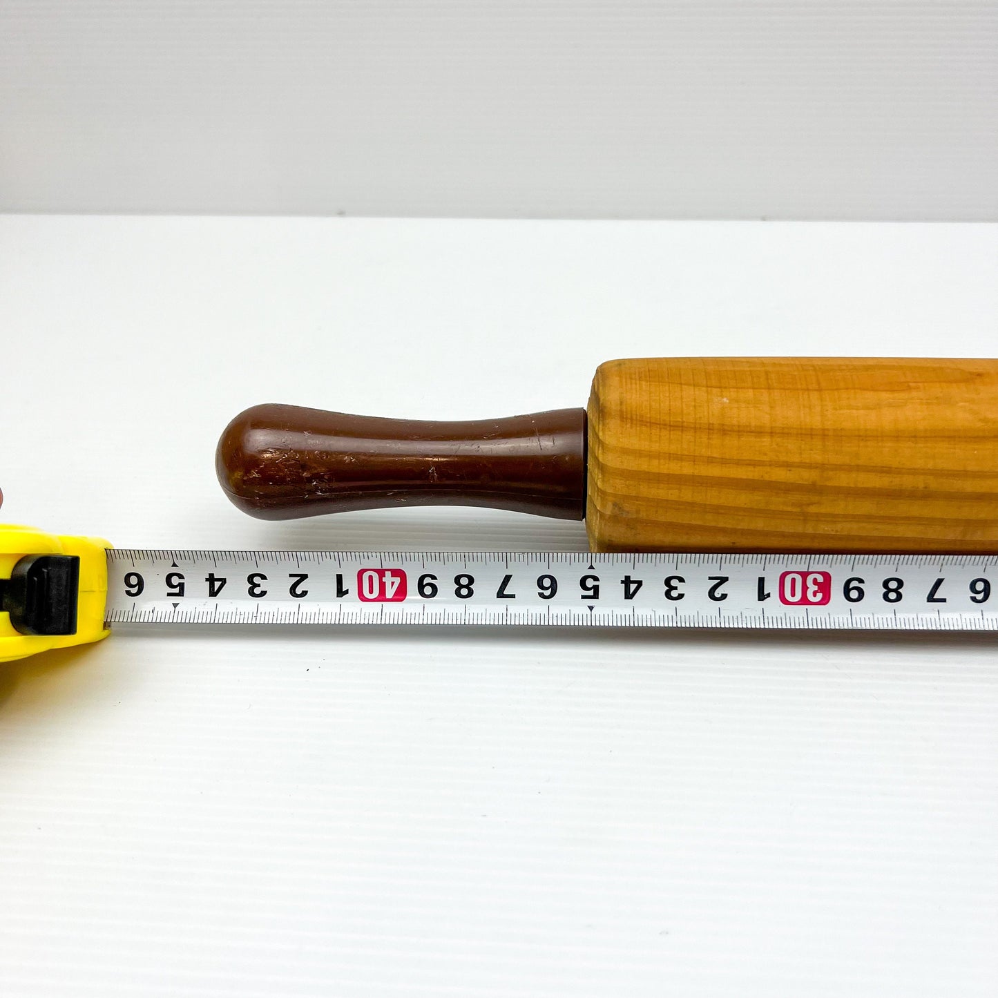 Wooden rolling pin with brown plastic handles