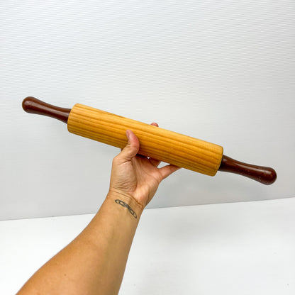 Wooden rolling pin with brown plastic handles